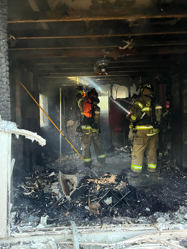 Firefighters inside a burned out house